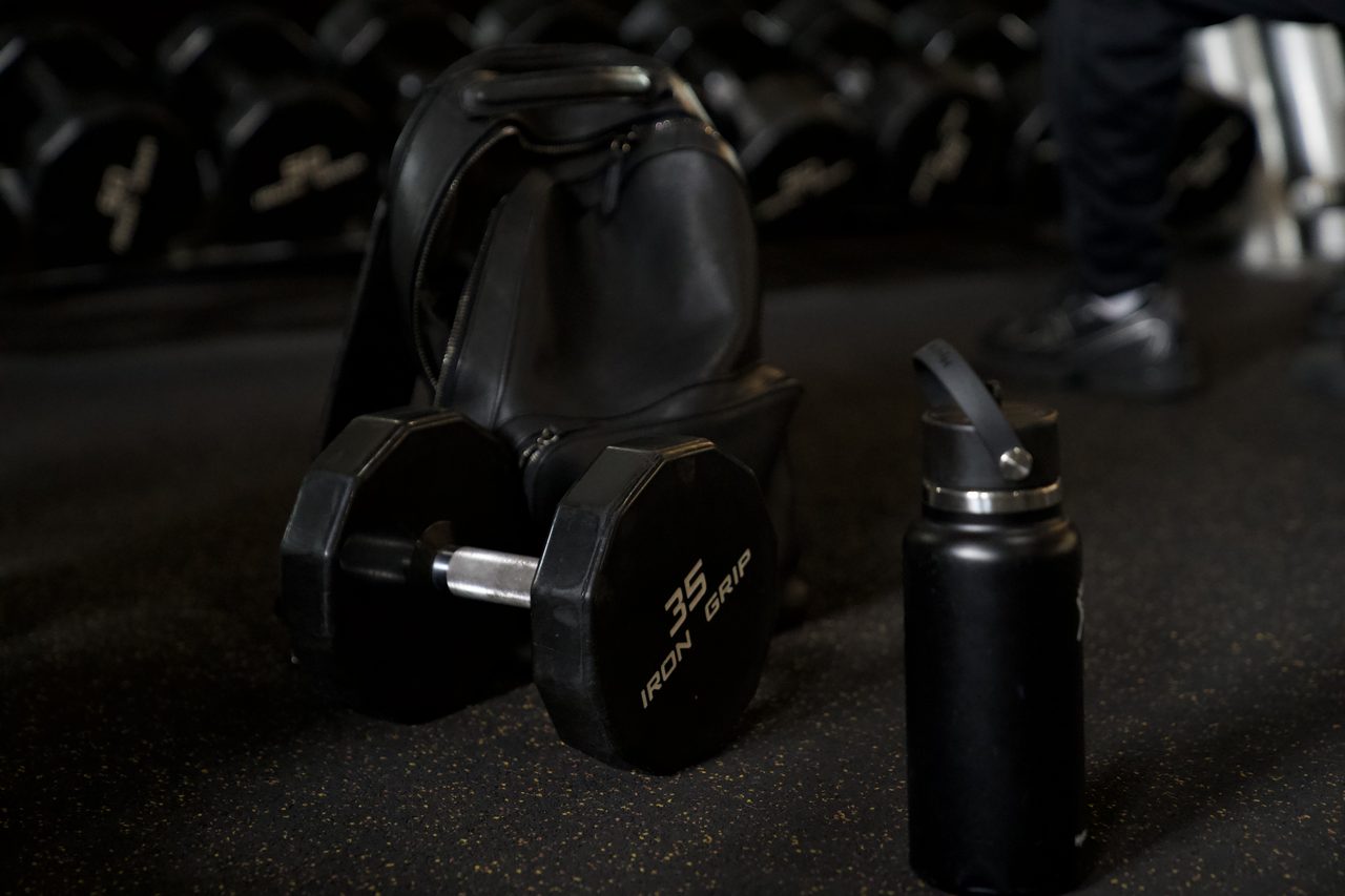 A 35-pound dumbbell, gym bag and water bottle on the weight floor