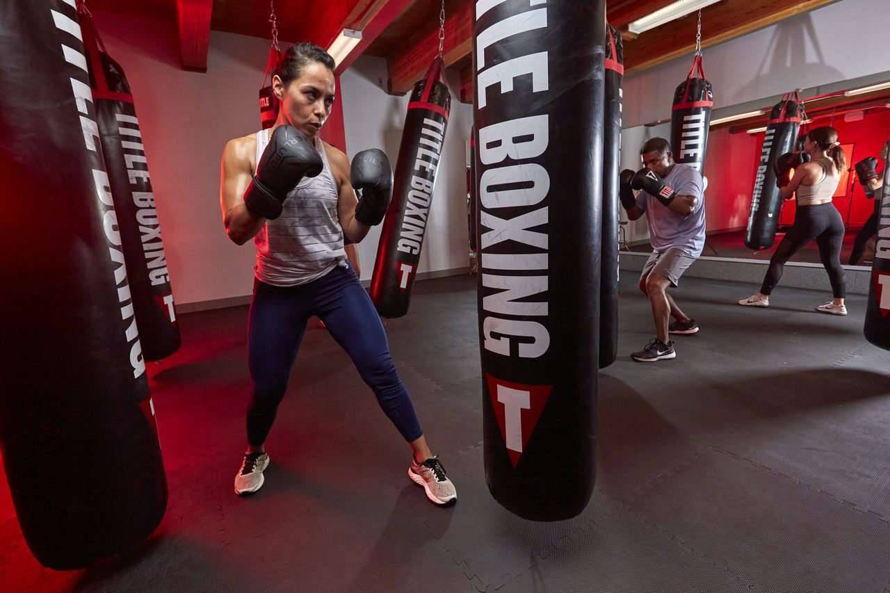 Members in a kickboxing class with heavy bags